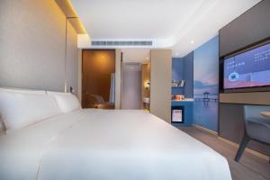 武汉武汉天地汉口江滩亚朵酒店的一间卧室配有一张大床和一台平面电视