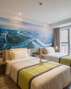 深圳深圳南山海岸城亚朵酒店的酒店客房设有两张床,墙上挂有绘画作品