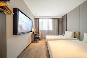 上海上海中环百联铜川路地铁站亚朵X酒店的酒店客房设有两张床和一台平面电视。