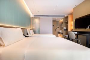 深圳深圳南山深圳湾亚朵轻居酒店的一张大白色的床,位于酒店客房内