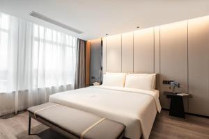厦门厦门高崎机场成功大道亚朵酒店的卧室设有一张白色大床和一扇窗户。
