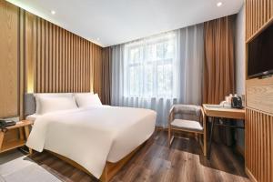 北京北京三里屯农业展览馆亚朵X酒店的卧室配有一张白色大床和一张书桌