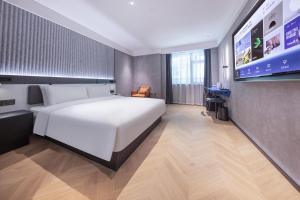福州福州三坊七巷轻居酒店的卧室配有白色的床和平面电视。