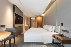 绍兴绍兴柯桥亚朵酒店的酒店客房设有一张白色大床和一张书桌