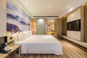 合肥合肥南站滨湖会展中心亚朵酒店的一间酒店客房,配有一张大床和一台平面电视