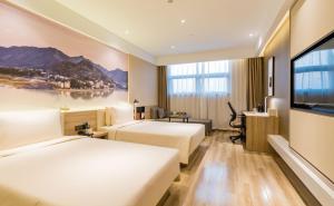 合肥合肥南站滨湖会展中心亚朵酒店的酒店客房设有两张床和一台平面电视。