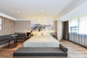 滨海新区天津滨海一大街亚朵酒店的一间卧室设有一张大床和一个大窗户