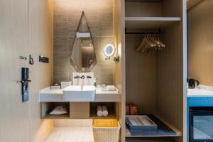 邯郸邯郸新世纪亚朵酒店的一间带水槽和镜子的浴室