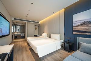 上海上海华泾亚朵酒店的一间卧室配有两张床和一台平面电视