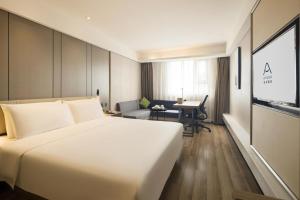 重庆重庆沙坪坝高铁站三峡广场亚朵酒店的酒店客房设有一张白色大床和一张书桌