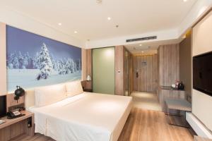 哈尔滨哈尔滨松北冰雪大世界亚朵酒店的卧室配有一张白色大床和电视。