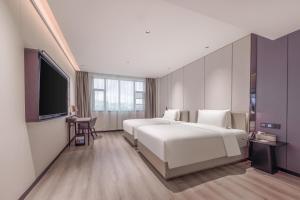 广州广州白云国际机场人和地铁站亚朵X酒店的酒店客房设有两张床和一台平面电视。