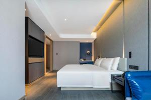 绍兴绍兴柯桥亚朵酒店的卧室配有一张白色大床和电视。