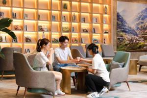 重庆重庆观音桥花卉园亚朵酒店的一群人坐在一个房间里桌子旁