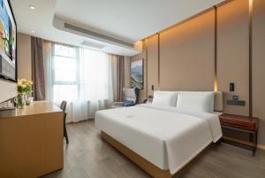 临海市台州临海台州学院亚朵酒店的卧室配有一张白色大床和一张书桌