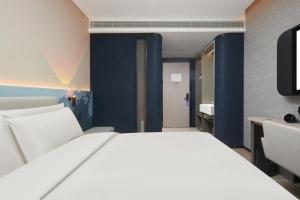 长沙长沙国金中心黄兴路步行街轻居酒店的一间带白色大床的卧室和一间浴室
