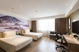 哈尔滨哈尔滨松北冰雪大世界亚朵酒店的酒店客房配有两张床和一张书桌