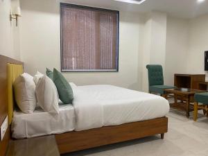 博帕尔Hotel Heera Residency的卧室配有1张床、1张桌子和1把椅子