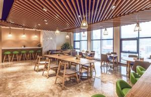西宁西宁昆仑东路亚朵酒店的餐厅设有桌椅和窗户。