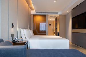 南昌南昌西站国际博览城亚朵酒店的酒店客房设有一张大床和一台电视。