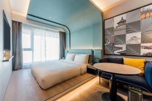 北京北京上地清河高铁站亚朵S酒店的一间卧室配有一张床、一张沙发和一张桌子