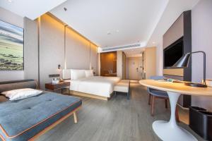 昆明昆明南悦城亚朵酒店的酒店客房配有一张床铺和一张桌子。