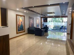 博帕尔Hotel Heera Residency的客厅配有沙发和墙上的绘画