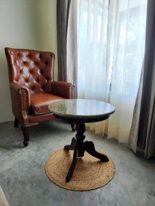 达兰萨拉Dev Bhoomi Farms & Cottages的客厅配有桌子和真皮座椅