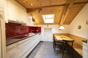 施库尔Chasa Rontsch Madlaina的厨房配有白色橱柜和木制天花板
