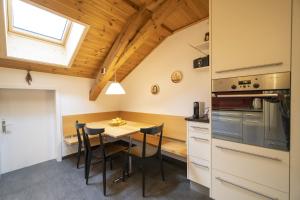 施库尔Chasa Rontsch Madlaina的厨房配有桌椅和窗户。