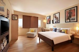 雅加达雅加达哈莫尼宜必思酒店的配有一张床和一台平面电视的酒店客房