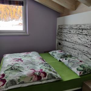 利维尼奥Al Dos的一间卧室配有一张带花卉棉被的床和窗户。