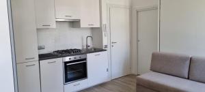 特伦托Maso kreuzberg- Monolocale 3- vista montagne的厨房配有白色橱柜和炉灶烤箱。