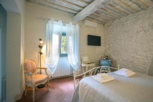 基安蒂盖奥勒博尔戈卡萨尔文托酒店的卧室配有床、椅子和窗户。