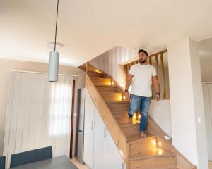 卡利诺岛Happinest Private Suite with Jacuzzi的一个人在房子里沿着木楼梯走