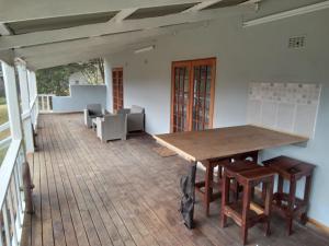 德尔斯特鲁姆Valley Of The Rainbow Estate的一间带木桌和椅子的用餐室