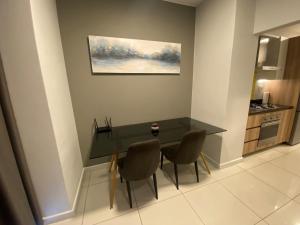 约翰内斯堡Easy Stay - The Median Rosebank的餐桌、两把椅子和墙上的绘画