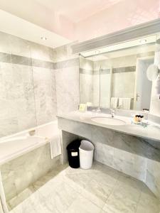 戛纳太阳里维拉酒店的一间带水槽、浴缸和镜子的浴室