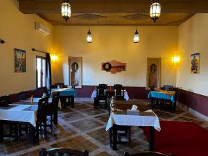 梅尔祖卡Dar Hassan Merzouga的用餐室配有桌椅和灯光