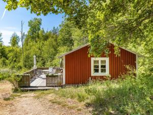 TingsrydHoliday Home Stenfors - SND035 by Interhome的树林中的红色小屋,设有甲板