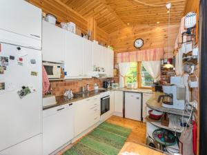 PiispalaHoliday Home Metsä-iivari by Interhome的厨房配有白色橱柜和木制天花板