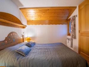 里雾诗Apartment Les Hauts des Chavants - by Interhome的一间卧室配有一张带蓝色枕头的大床