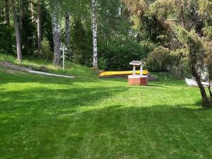 PaksaloHoliday Home Lomaranta by Interhome的草上有一个黄色滑梯的公园