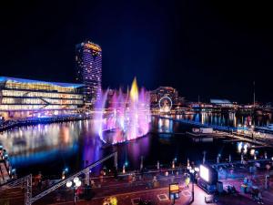 悉尼悉尼达令港索菲特酒店的夜水里有一个喷泉的城市