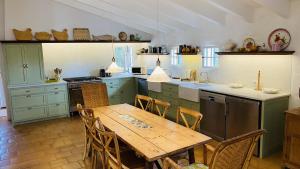 圣克莱蒙Holiday Home Casa MADORIA的一间带木桌的厨房和一间带绿色橱柜的厨房