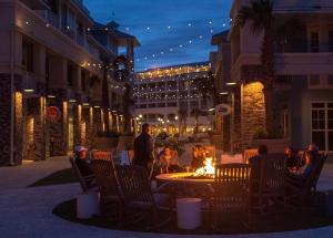 棕榈岛Wild Dunes Resort - Residences at Sweetgrass的一群人坐在庭院的火炉旁