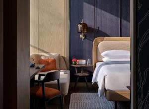 南京南京河西安达仕酒店的配有床、椅子和桌子的酒店客房