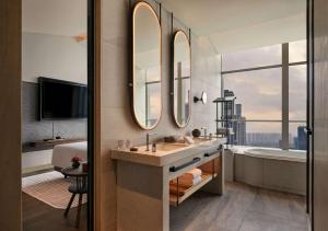 南京南京河西安达仕酒店的一间带水槽、浴缸和镜子的浴室