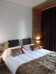 蒙卢伊Hotel et Résidence Le Clos Cerdan的一间卧室配有一张大床和两个枕头