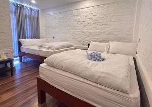 博卡拉Dhikidada Resort的墙上的房间里设有两张床